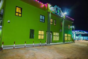 ein grünes Gebäude mit seitlicher Beleuchtung in der Unterkunft United Hotel Balessing in Balessing