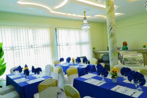 ein Konferenzraum mit blauen Tischen und weißen Stühlen in der Unterkunft United Hotel Balessing in Balessing