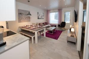 a kitchen and living room with a table and a couch at Beautiful and peaceful home near Levi center in Kittilä