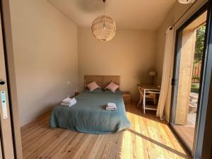 ein Schlafzimmer mit einem Bett und einer Hängeleuchte in der Unterkunft La petite Dépendance in Le Bouscat