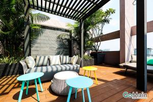 a patio with two tables and a couch on a deck at 24h Check in & SkyPool- KL Sentral Suite Riveria City Near KL Sentral KL KLCC in Kuala Lumpur