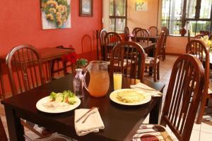 uma mesa preta com dois pratos de comida em Hotel Finca Las Hortensias em Tepotzotlán