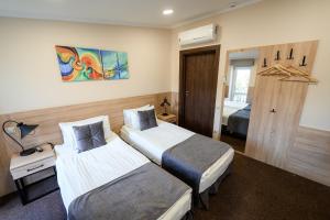 リヴィウにあるNota Bene Loftのベッドが2つと窓があるホテルの部屋 +58枚の写真