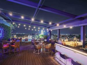 a rooftop bar with tables and chairs on a deck at Ibis Saigon Airport in Ho Chi Minh City
