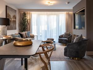 a living room with a table and chairs at Arran Shores Luxury Shorefront Garden Terrace Apartment 6 in Lamlash