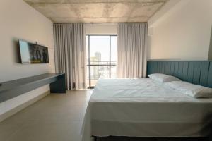 a bedroom with a bed and a large window at Apartamento Centro Prime CA1404 in Maringá