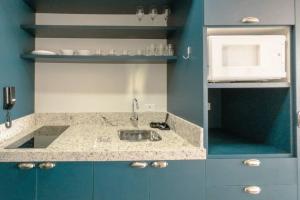 a blue and white kitchen with a sink at Apartamento Centro Prime CA1404 in Maringá +26 photos