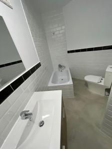 une salle de bain blanche avec un lavabo et des toilettes dans l'établissement Creativity Quarters Habitación temporada en coliving para estudiantes, trabajadores y artistas, à Madrid 29 autres photos