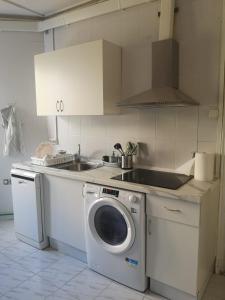 une cuisine avec une machine à laver et un évier dans l'établissement Creativity Quarters Habitación temporada en coliving para estudiantes, trabajadores y artistas, à Madrid