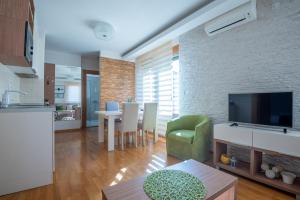 eine Küche und ein Wohnzimmer mit einem TV und einem Tisch in der Unterkunft Konačište Egoiste - Centar in Zlatibor