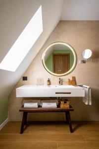 a bathroom with a sink and a mirror at Hotel Valedor Boutique & Spa in Buşteni