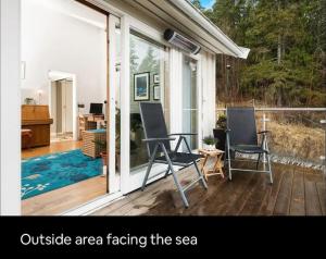 an outside area facing the sea with two chairs on a porch at Eget rom og bad med delt kjøkken, 15 minutter fra Trondheim in Malvik +5 photos
