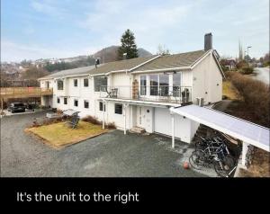 a large white house with according to the title it is the unit to at Eget rom og bad med delt kjøkken, 15 minutter fra Trondheim in Malvik
