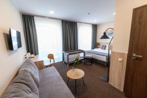 a living room with a couch and a bedroom at Nota Bene Loft in Lviv