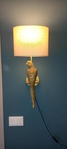a lamp with a bird on a blue wall at Novecento in Bertinoro