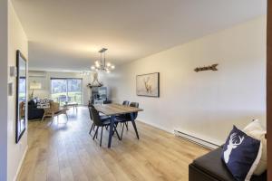 a dining room and living room with a table and chairs at Cozy Chalet on the 9th Hole La Bête Pool Golf in Mont-Tremblant