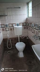 a bathroom with a toilet and a sink at Giridhama homestay in Chikmagalūr
