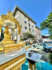 a gold temple with a table in front of a building at Nakara Place บ้าน นาครา in Ban Rang Pho