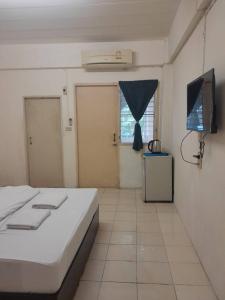 a bedroom with a bed and a flat screen tv at Nakara Place บ้าน นาครา in Ban Rang Pho