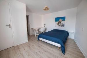 a bedroom with a blue bed and a table at PICH Grande maison centre-ville in Thouars