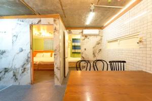 ソウルにあるB-Gu & Anne House Hongik Stationのテーブルと椅子と寝室のある部屋