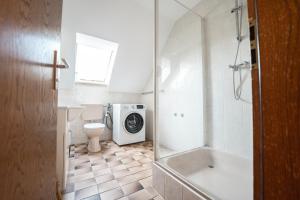 a bathroom with a toilet and a washing machine at Gästezimmer Kalb in Schweinfurt +27 photos