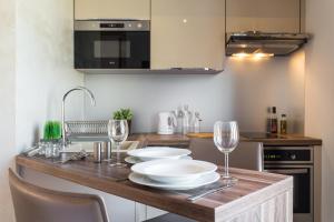 a kitchen with a table with plates and wine glasses at Villa Velvet in Villeneuve-Loubet