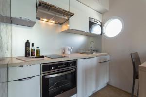 a kitchen with white cabinets and a black oven at Villa Velvet in Villeneuve-Loubet