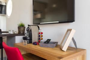 a wooden table with a television on a wall at Villa Velvet in Villeneuve-Loubet
