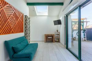 sala de estar con sofá verde y puerta corredera de cristal en Appartement Iruba - Welkeys, en Saint-Pierre-dʼIrube