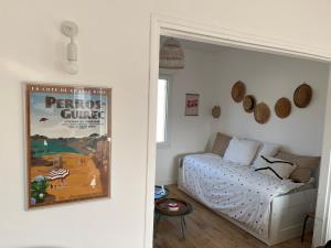 a room with a bed and a poster on the wall at Gigi La Roza in Perros-Guirec