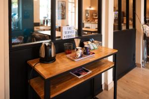 a table in a store with a coffee maker on it at Hôtel Bellevue in Brest