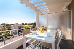 a white table and chairs on a balcony with a view at Villa Velvet in Villeneuve-Loubet