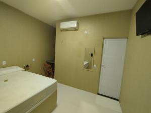 a bedroom with a bed and a window and a door at Karajas Hotel in Quixeramobim