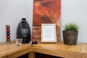 a coffee maker on a wooden table with a picture at Villa Velvet in Villeneuve-Loubet