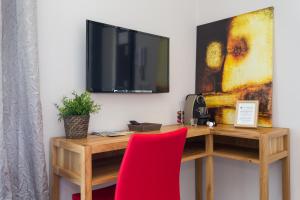a desk with a tv and a red chair at Villa Velvet in Villeneuve-Loubet