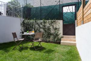 a table and chairs in the grass in a backyard at Villa Velvet in Villeneuve-Loubet