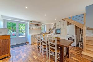 a kitchen with a wooden table and chairs in a room at Ker Breizh - Saint Pabu - 14 pers in Saint-Pabu +20 photos