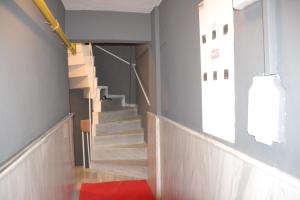a hallway with stairs in a building with a red rug at Huzur 1 in Edirne