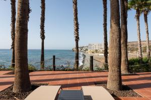 a patio with palm trees and the ocean at Suite Altamar, 2 Bedroom - by Gestión Vacacional Canarias in Playa del Aguila +26 photos