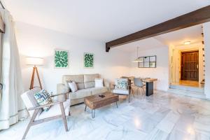 een woonkamer met een bank en een tafel bij Casa Jardines del Sol 4 in Marbella