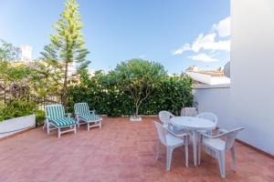 een patio met witte stoelen en een tafel en stoelen bij Casa Jardines del Sol 4 in Marbella