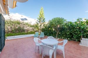 een patio met een witte tafel en stoelen bij Casa Jardines del Sol 4 in Marbella +18 foto's
