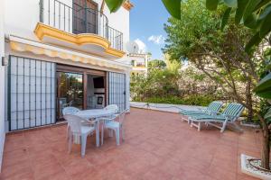 een patio met een tafel en stoelen bij Casa Jardines del Sol 4 in Marbella