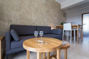 a living room with a couch and two wine glasses on a table at Villa Velvet in Villeneuve-Loubet