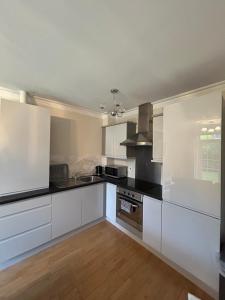a kitchen with white cabinets and black counter tops at Stockmans Stay, Belfast in Belfast +21 photos