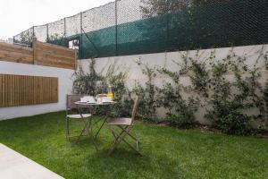 a table and chairs in a backyard with a fence at Villa Velvet in Villeneuve-Loubet