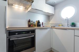 a kitchen with white cabinets and a black oven at Villa Velvet in Villeneuve-Loubet