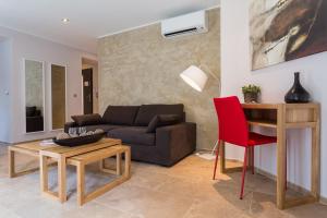a living room with a couch and a red chair at Villa Velvet in Villeneuve-Loubet