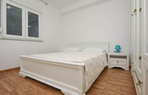 a white bedroom with a bed and a window at Relax 1 in Pakoštane
